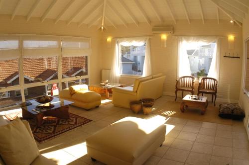 a living room with yellow chairs and a table at Carilo Soleil By HS in Carilo
