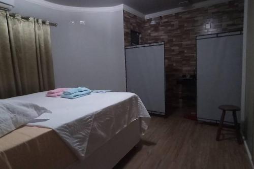 a bedroom with a bed with towels on it at Aconchego perto das Cataratas. in Foz do Iguaçu