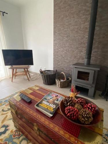 a living room with a table with a bowl of fruit and a fireplace at Ferroa Guest House in Cano