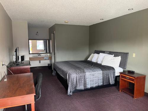 a hotel room with a bed and a desk at Hallmark Inn and Suites in San Antonio