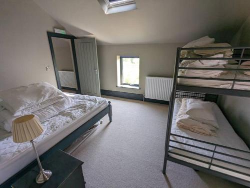 a bedroom with two bunk beds and a lamp at The Barn at Linwood Hall Farm in Martin