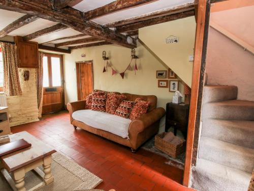 - un salon avec un canapé et un escalier dans l'établissement Castle Cottage, à Clun