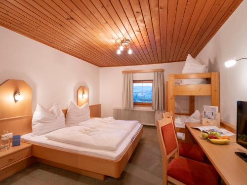 a bedroom with a bed and a desk and a bunk bed at Gasthof Mamooserhof in Penning