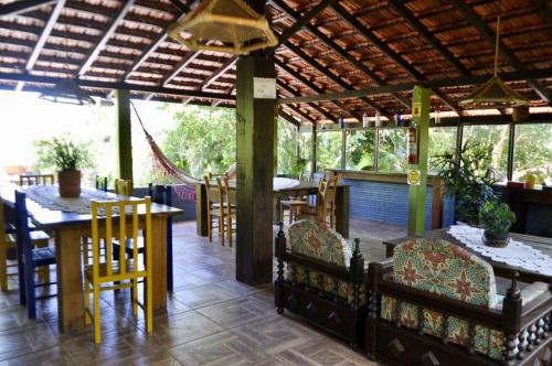 a restaurant with tables and chairs and a roof at Residencial Recanto Ferrugem in Garopaba