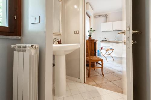 a white bathroom with a sink and a kitchen at Francesco Redi Camere in Arezzo