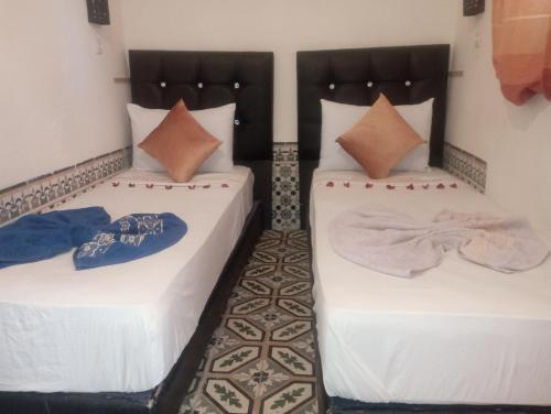 two beds sitting next to each other in a room at RIAD DAR LFONOUN in Marrakech
