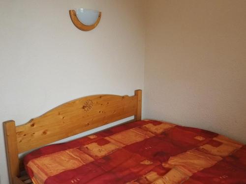- une chambre avec un lit en bois et une lumière sur le mur dans l'établissement Appartement cozy 2 pièces · Proche pistes et commerces · Balcon sud/est · 4 pers - FR-1-344-1023, aux Menuires