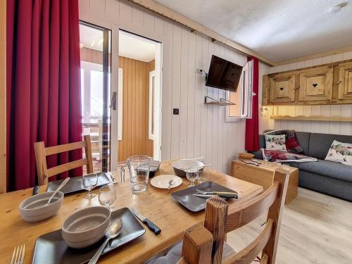 une salle à manger avec une table et un canapé dans l'établissement Studio classique aux Menuires, balcon, animaux admis - FR-1-344-1038, aux Menuires