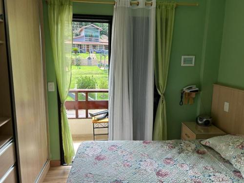 a bedroom with a bed and a view of a balcony at Piemonte Flat Hotel in Serra Negra