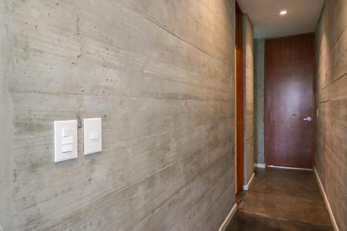 un pasillo con una pared de madera con dos interruptores de luz en Modern 4BR Villa with Private Pool in Paracas en Paracas