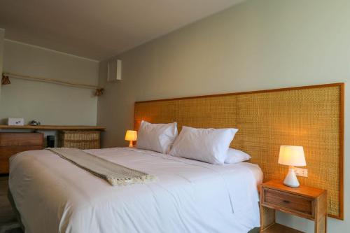 1 dormitorio con 1 cama blanca grande y 2 lámparas en Modern 4BR Villa with Private Pool in Paracas en Paracas