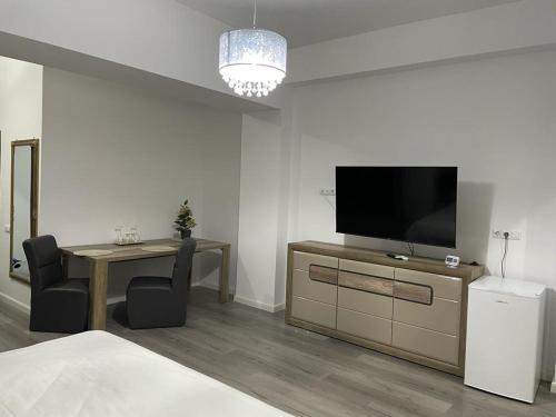 a bedroom with a television and a table with chairs at Ap Nou Rezidential Faleza in Galaţi