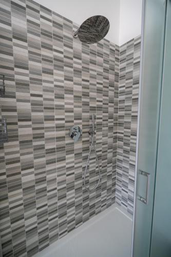 a bathroom with a shower with brown tile at Luna apartment in Aci Castello