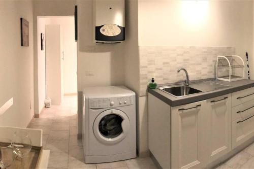 una cucina con lavatrice e lavandino di Comfortable Apartment in Sant'Orsola a Bologna