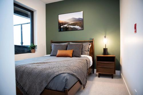 a bedroom with a bed and a window at Powder & Pines - Cozy 2 Bedroom with Hot Tub in Revelstoke