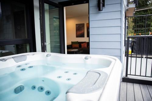 bañera blanca en la cubierta en Powder & Pines - Cozy 2 Bedroom with Hot Tub en Revelstoke