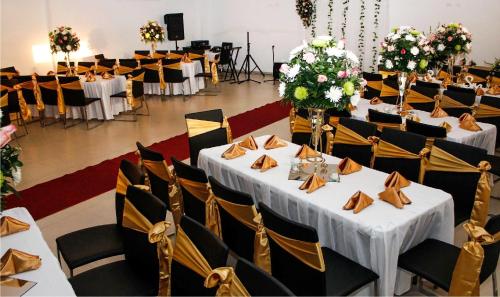 a banquet hall with white tables and chairs at Hotel la Ciudad in Barrancabermeja