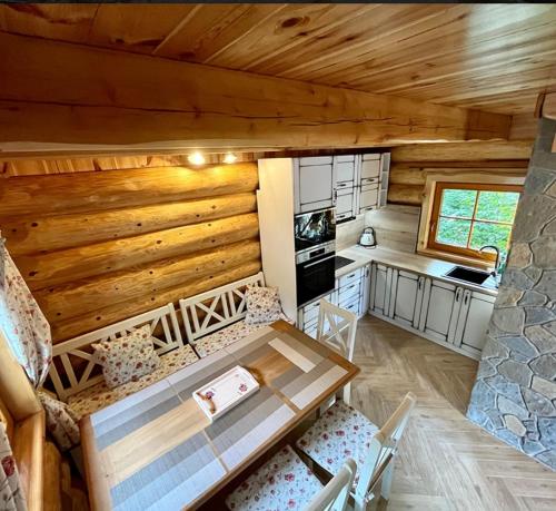 a kitchen and living room of a log cabin at Zrubový Dom 1 v Panoráma Parku in Nezbudská Lúčka