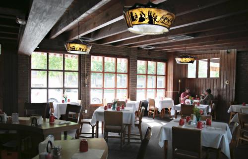 a dining room with white tables and chairs and windows at Dude Rancher Lodge in Billings