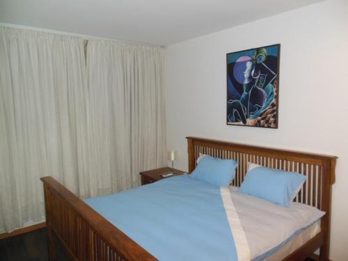 a bedroom with a large bed with blue pillows at Residence Palmeira II in Beira