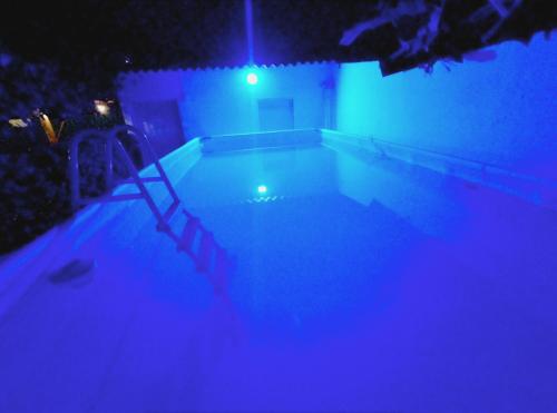 - une piscine avec des lumières bleues dans une maison dans l'établissement Hostal Baruch, à Buritaca