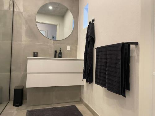a bathroom with a sink and a mirror at Hyggelig nyrenoveret lejlighed til 4 Personer in Agerbæk