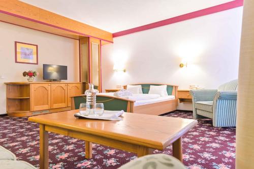 a hotel room with a bed and a table at Ferienhotel Alber in Mallnitz