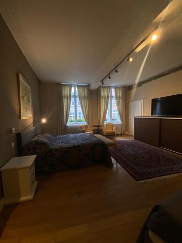 a bedroom with a bed and two windows at Guesthouse 1640 in Bruges