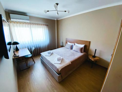 - une chambre avec un lit, une table et une fenêtre dans l'établissement Celorico Village AP, à Castelbuono