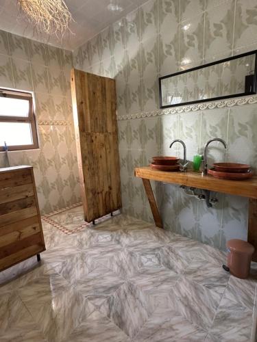 a bathroom with a tiled floor with a sink and a counter at DAR SANAE SURF in Aourir