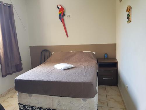 a bedroom with a bed and a dresser with a parrot on the wall at VilaVerin Apartments in Manaus