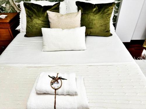 Una cama blanca con un reloj encima. en Hoibai, Apt Bolboreta, elegante, céntrico, cómodo, en Baiona