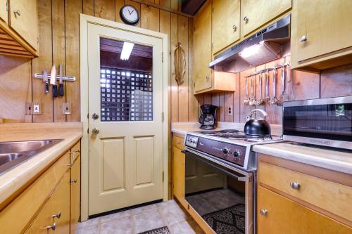 a kitchen with a stove and a sink and a door at 3 Mi to Big Trees State Park Cabin with Deck in Arnold