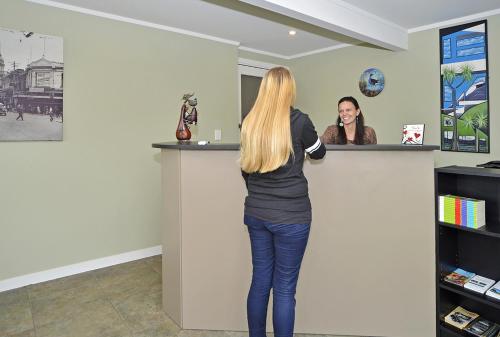 a woman standing at a counter talking to a woman at Welcome Inn Motel Levin in Levin