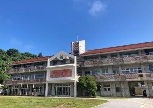 a large building with a red roof at LivingAnywhere Commonsうるま Male Dormitory - Vacation STAY 15539v in Uruma