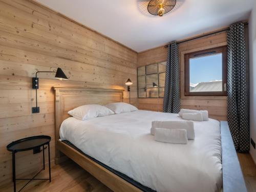 a bedroom with a large white bed with a window at Appartement Courchevel 1650, 4 pièces, 6 personnes - FR-1-563-36 in Courchevel
