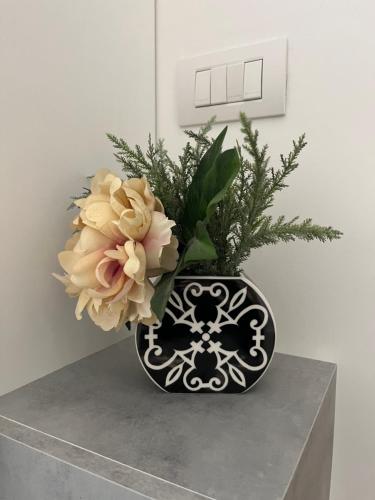 um vaso preto e branco com flores sobre uma mesa em Appartamento Vacanze Romane em Roma