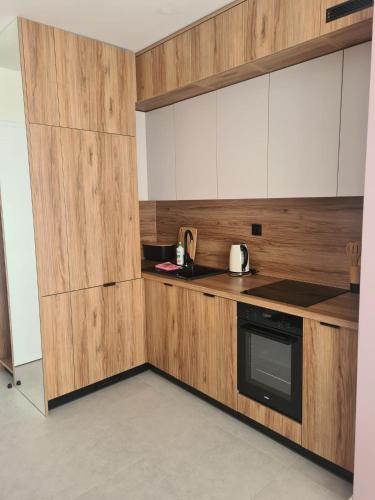a kitchen with white cabinets and a black oven at Apartamenty z widokiem na Śnieżkę in Karpacz