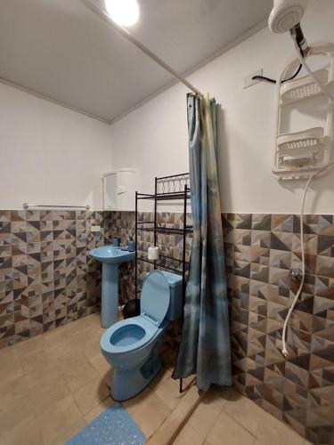 a bathroom with a blue toilet and a sink at Paradise Venao - Cañas in Cañas