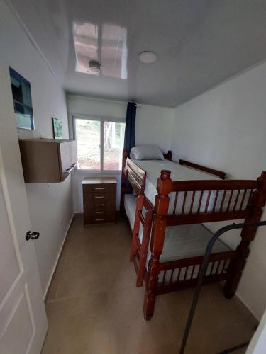 a small bedroom with a bunk bed and a window at Paradise Venao - Cañas in Cañas