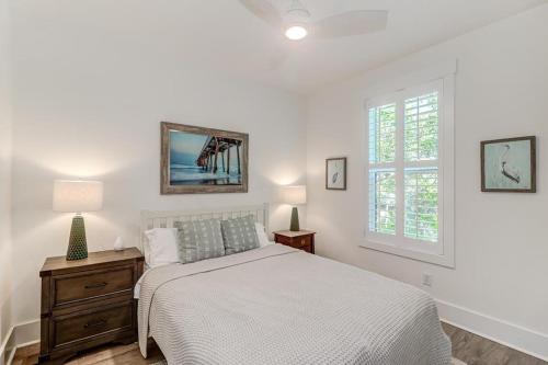 um quarto branco com uma cama e uma janela em 1004 Mariner's - Fin & Tonic em Folly Beach