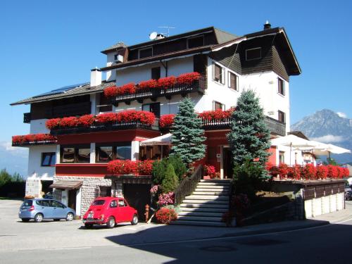 a building with cars parked in front of it at Albergo Trieste in Tambre dʼAlpago
