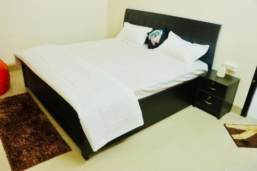 een slaapkamer met een groot bed met een zwart hoofdeinde bij Radiant luxury apartment in Agra