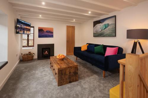 a living room with a couch and a fireplace at The Snug in Mousehole in Mousehole