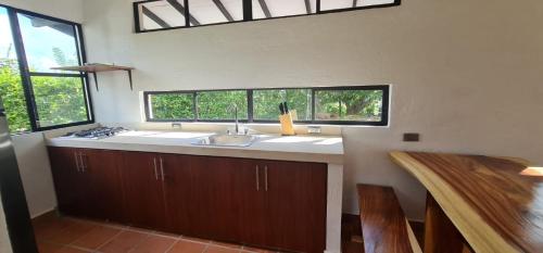uma cozinha com um lavatório e duas janelas em EL PARAISO em Sopetrán