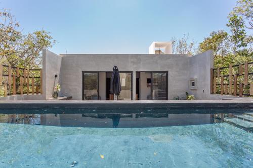 a house with a swimming pool in front of a house at Luxury private villa-infinity pool&jungle view in Tulum