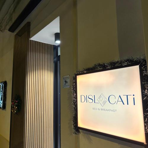 a sign on the side of a building at Dislocati BnB - Jacuzzi privata - Cucina - TV60" - Minimal Luxury in Marigliano