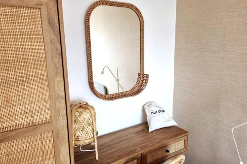 a mirror on top of a wooden dresser in a bathroom at 1Rosemount -Marazion - Iconic view of St Michaels Mt, Sea, Beach, 2xParking, Netflix Prime in Marazion
