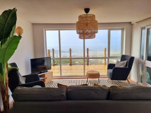 a living room with a couch and a large window at 1Rosemount -Marazion - Iconic view of St Michaels Mt, Sea, Beach, 2xParking, Netflix Prime in Marazion