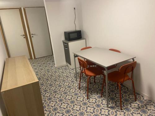a room with a table and chairs and a television at 2 bedroom and kitchen in Mons
